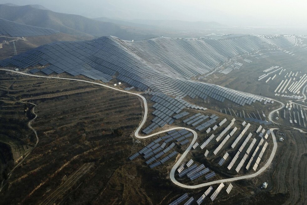 Aerial view of a vast utility-scale solar PV farm covering mountain ridges in China