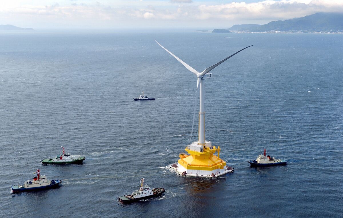 Floating offshore wind turbine being towed by support vessels