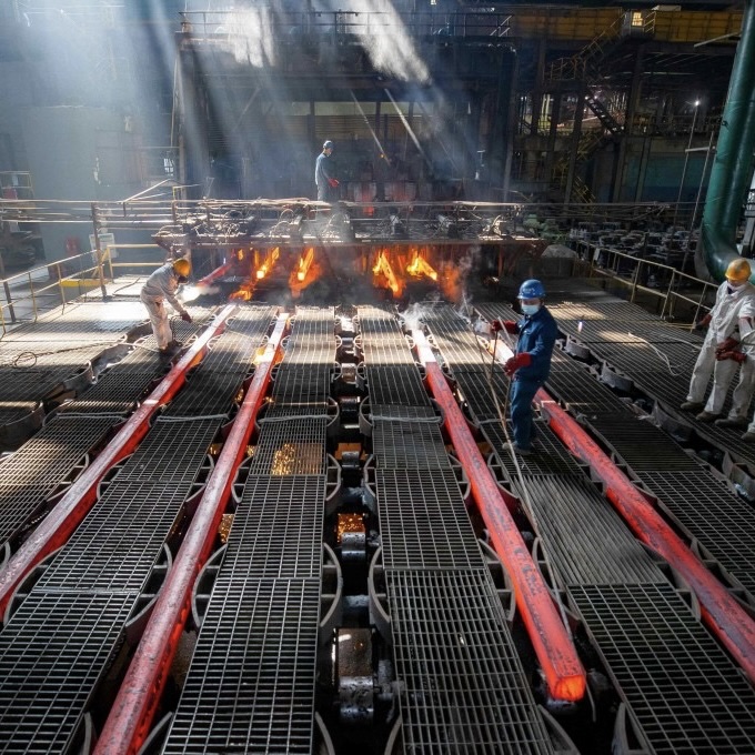 Workers in a Chinese steel mill processing red-hot steel billets